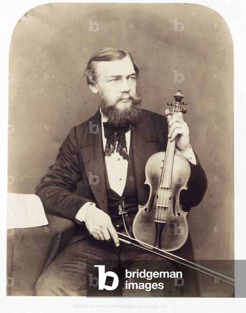 Violinist seated with Stradivarius.