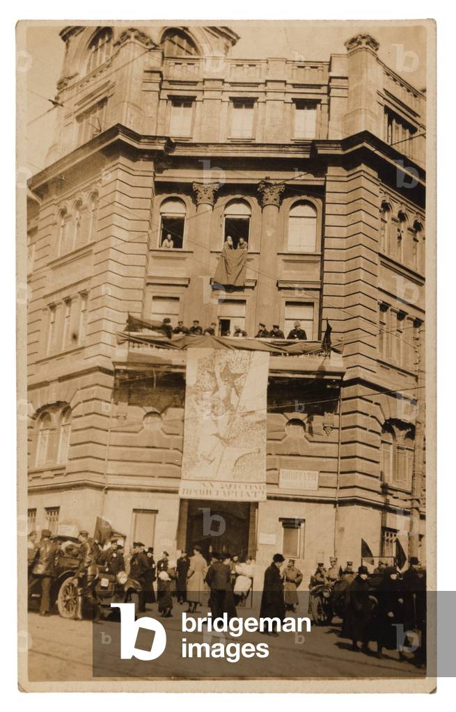 Postcard depicting Crowds in Vladivostok standing beneath a large Revolutionary Propaganda Placard, c.1920
