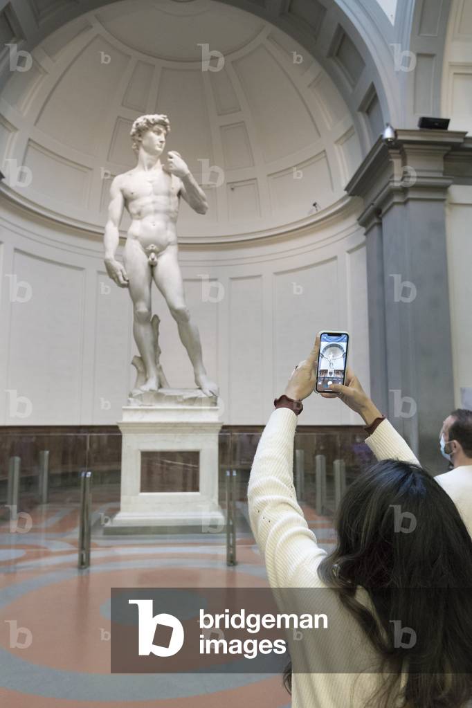 Taking a photo in front of the statue of David by Michelangelo,
