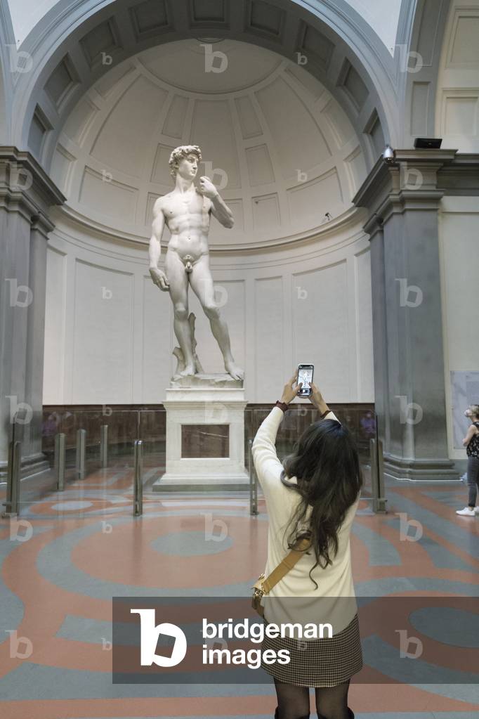 Taking a photo in front of the statue of David by Michelangelo,
