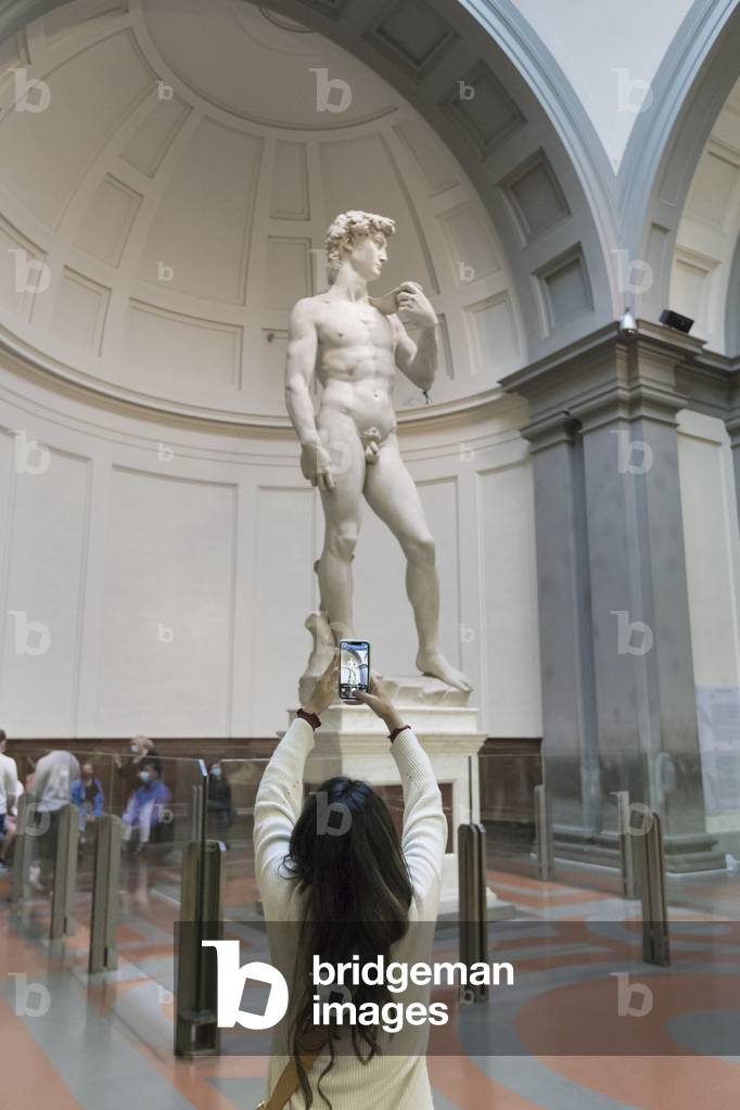 Taking a photo in front of the statue of David by Michelangelo,