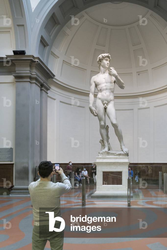 Taking a photo in front of the statue of David by Michelangelo,