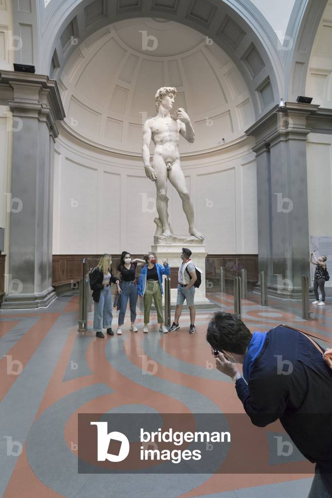 Taking a photo in front of the statue of David by Michelangelo,