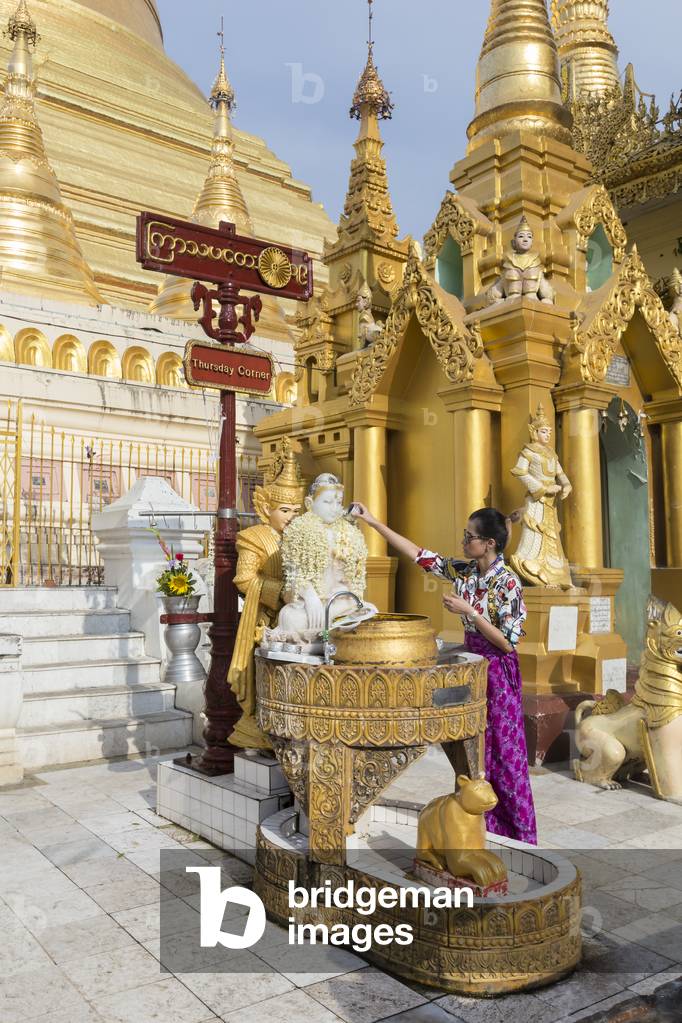 People pooring water over a Buddha statue, Shwedagon pagoda, Yangon, Myanmar