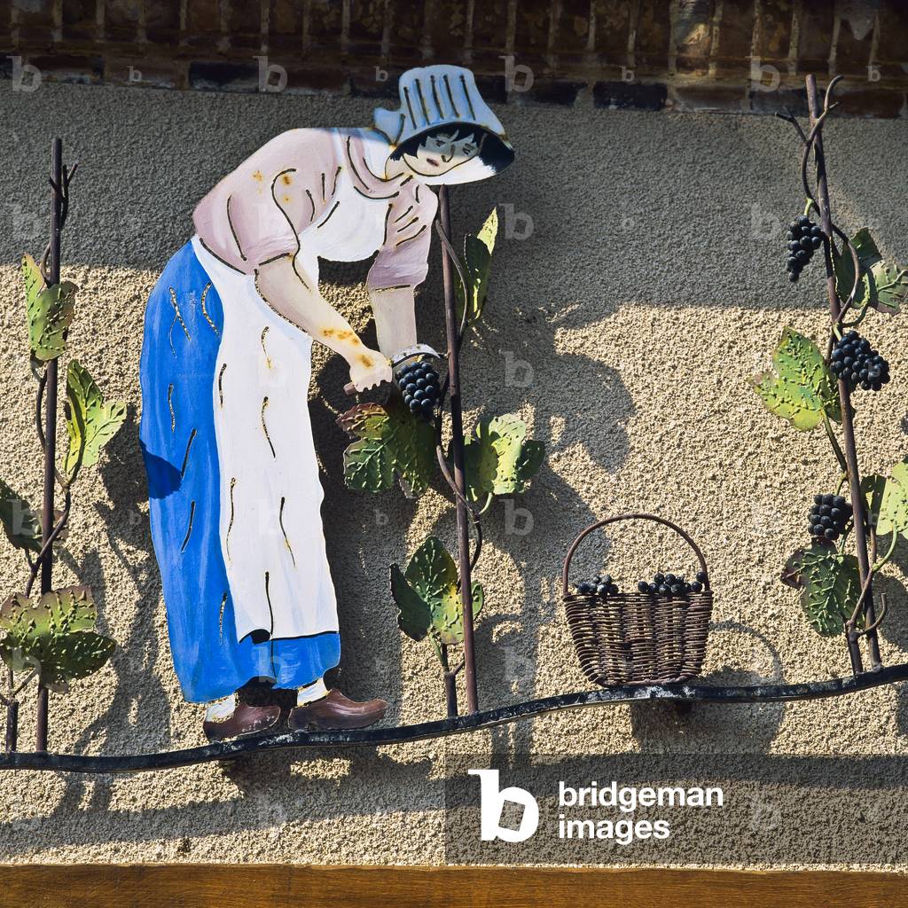Wrought-iron sign with a woman picking grapes, Hautvillers, Champagne, France (photo)