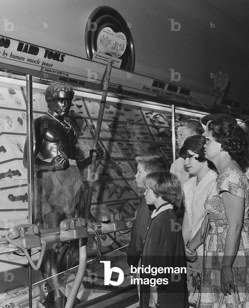 A Family Looking At A Display Which Traces The Story Of Tools And Man's Progress