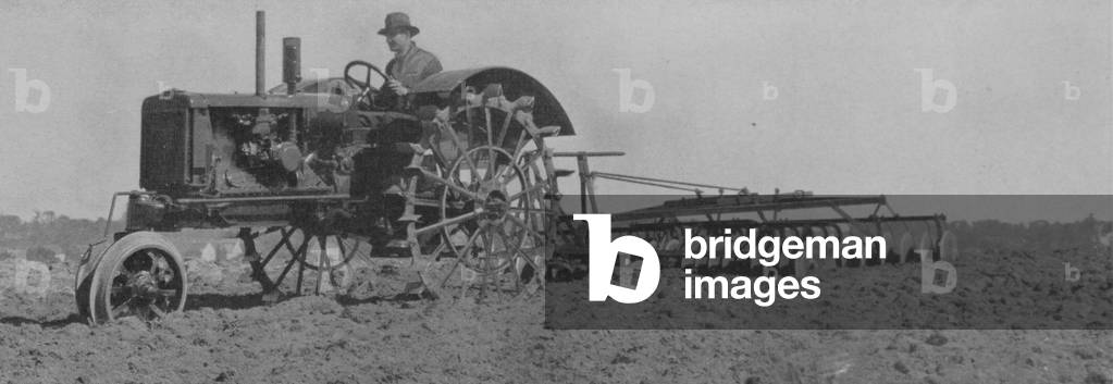 Farmer Using A Row Crop Tractor Equipped With Tiptoe Wheels To Do Tillage Work