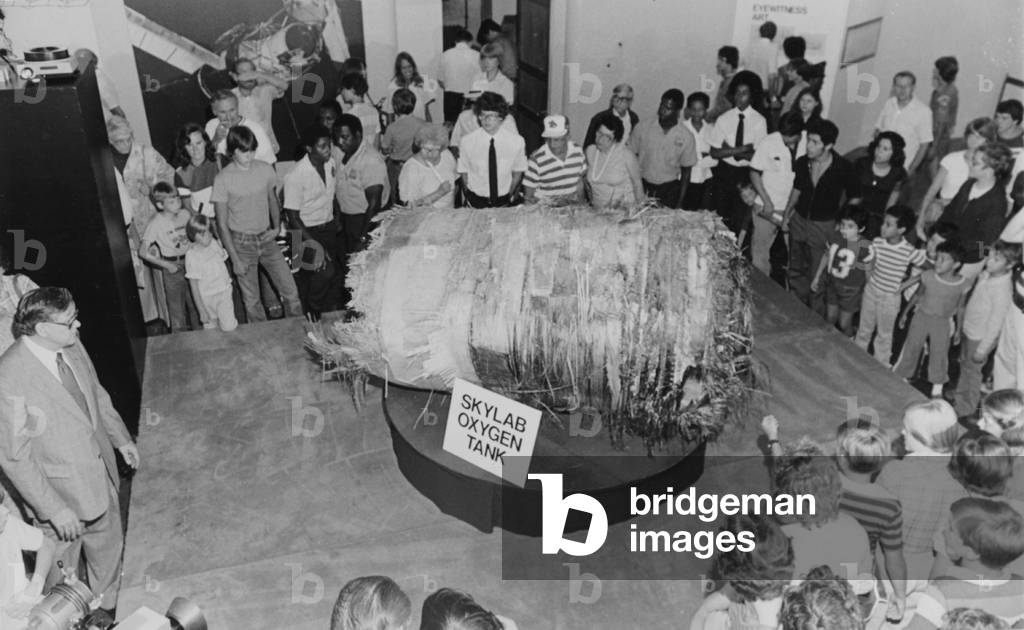 A Group Of People Looking At One Of The Oxygen Tanks From Skylab On Display