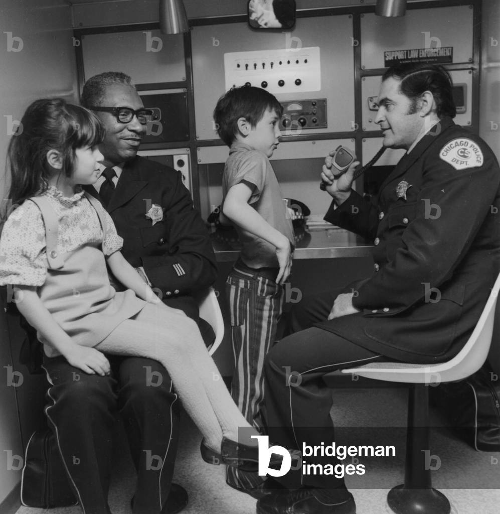 Two Young Children Touring The Mobile Police Unit With Officers Of The Chicago Police Force