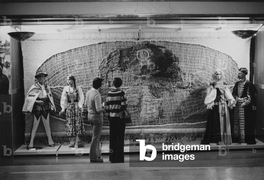 A Group Of People Viewing A Large Macramé Object On Display