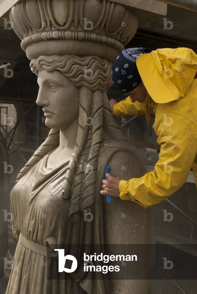 A Museum Employee Cleaning One Of The Caryatid On The Façade Of The Museum Of Science And Industry
