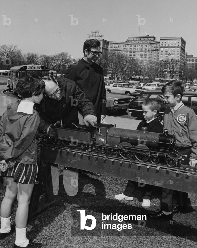 A Man Explaining A Steam Locomotive To A Group Of Children
