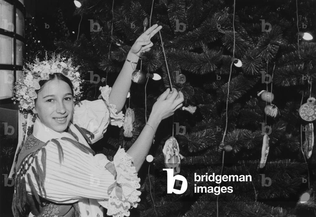 A Girl Decorating One Of The Many Ethnic Themed Trees During The Annual Christmas Around The World Festival
