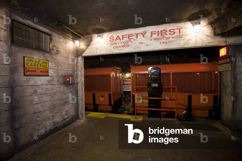 A Coal Mine Train And Boarding Platform With Multiple Safety Notices Posted Around It