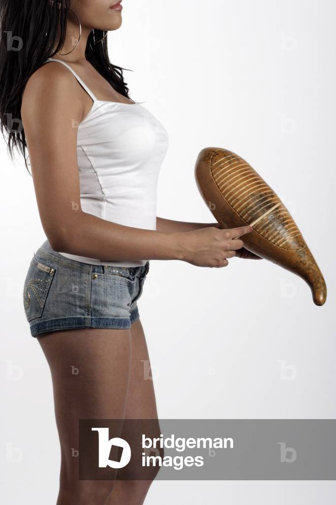 Young Brazilian woman playing a Guiro