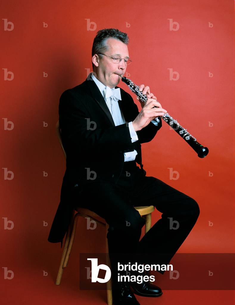 Man playing oboe against