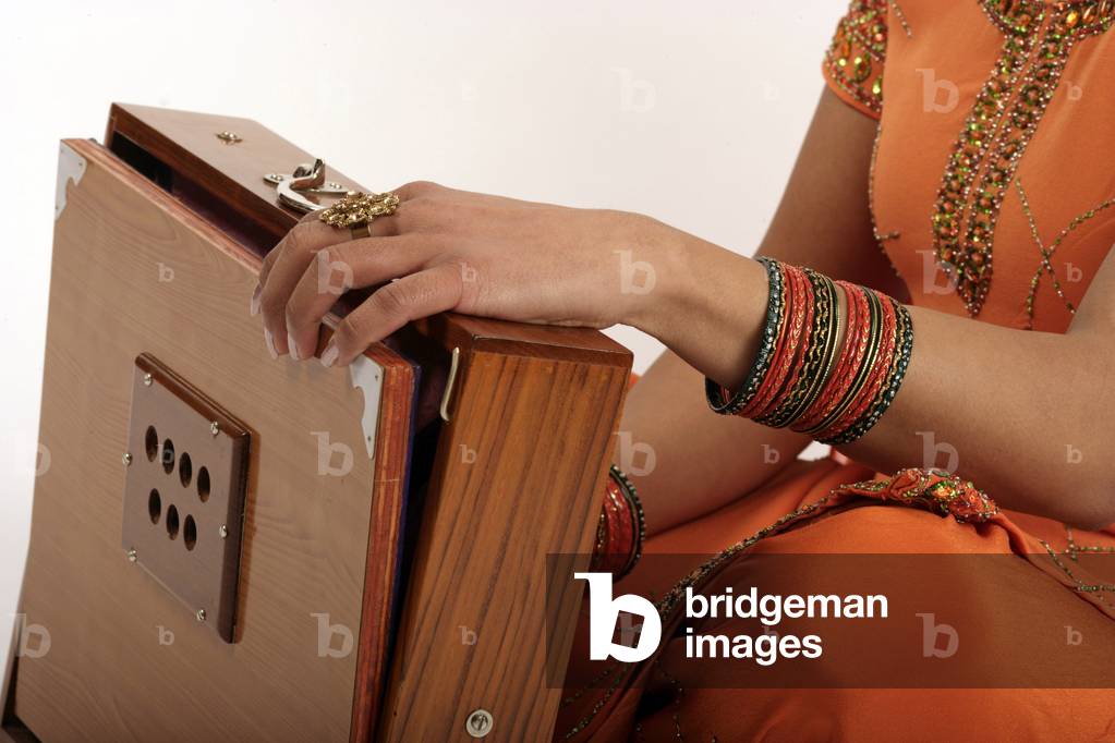 Shurti Box - portrait of a young Indian woman playing the Shurti Box, a simple Indian harmonium made with English reed.