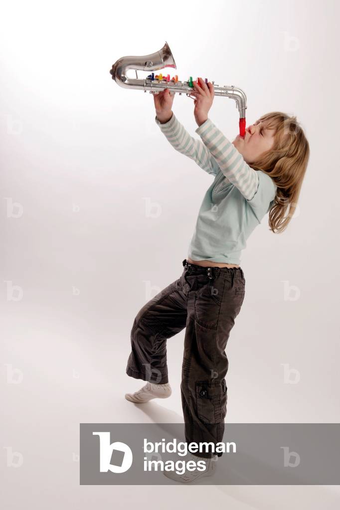 Young girl playing a toy trumpet