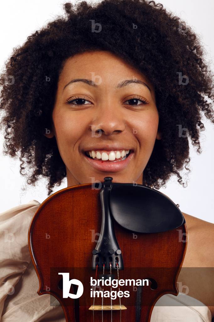 Violin player holding her instrument near her face