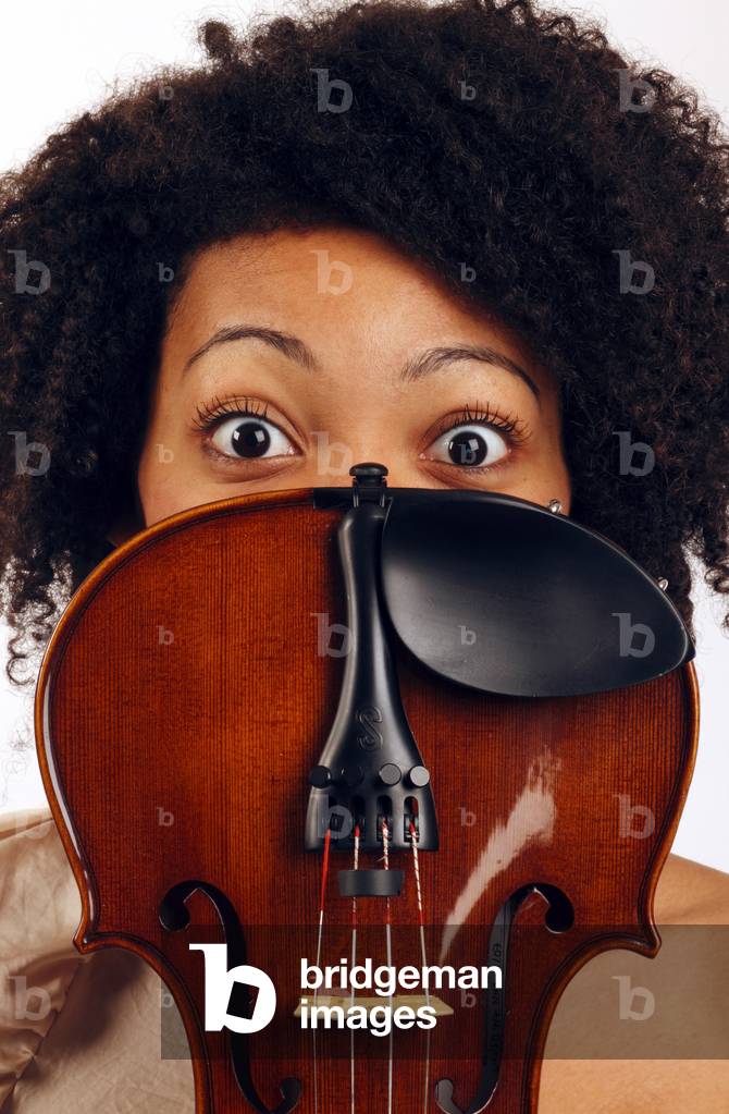 Violin player holding her instrument near her face