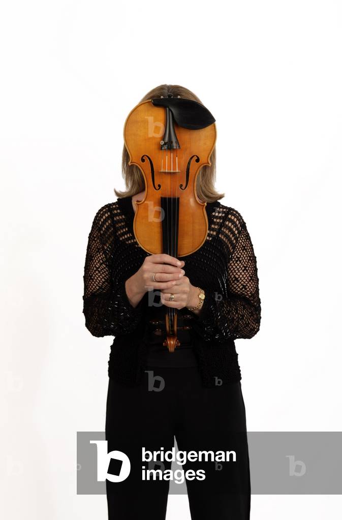 Violin player holding her violin in front of her face