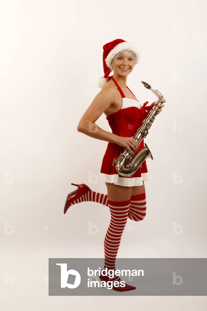 Young woman in a Miss Santa outfit holding an Alto Saxophone.