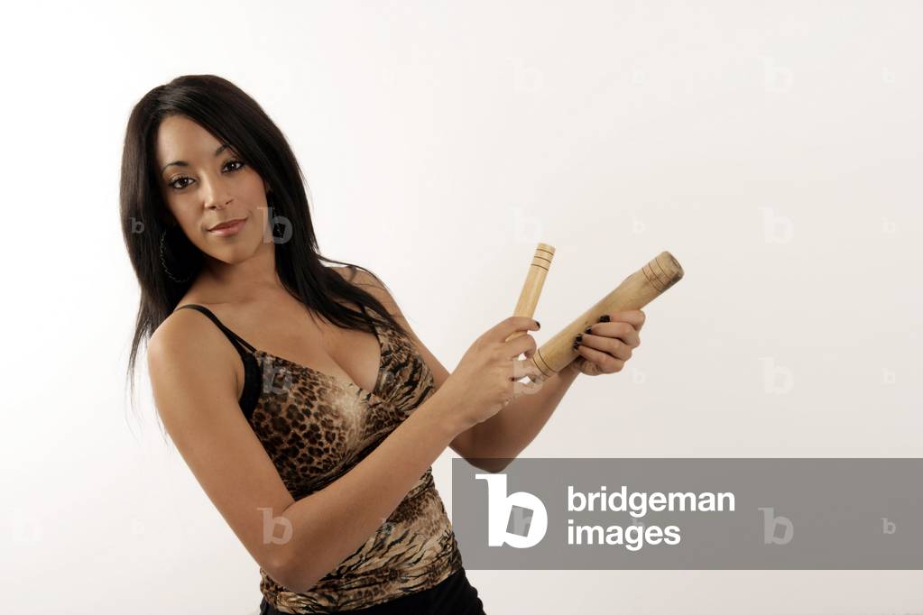 Young woman playing a pair of cuban claves