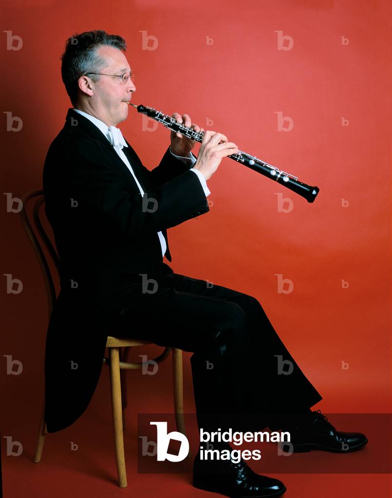 Man playing oboe against