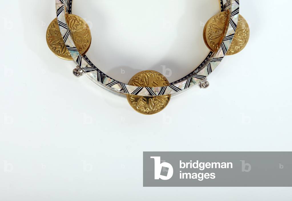 Riq, or Riqq, Egyptian Tambourine held vertically in one hand, and played by striking the skin with the other hand, as well as playing the heavy jingles with the fingers of both hands. Arabic. Generic