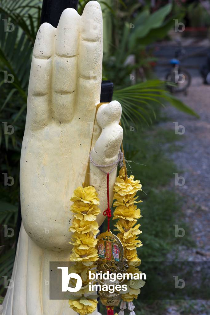 Amulets for good luck hanging on a hand statue, Andaman Island, Thailand (photo)