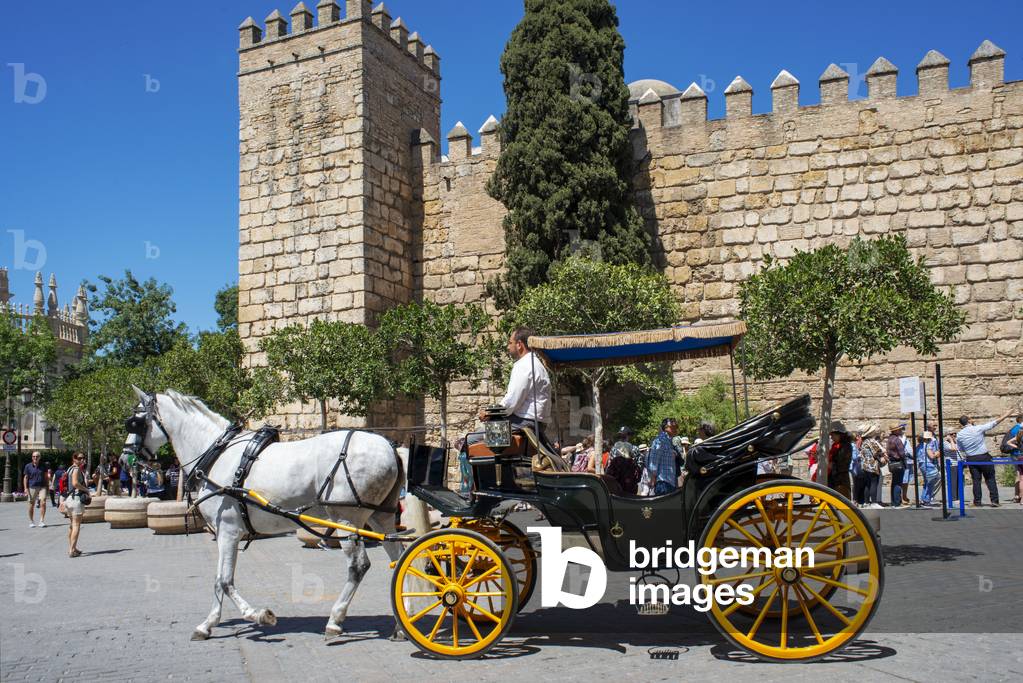 Horse and carriage ride with walls of Real Alcazar Seville, Spain (photo)