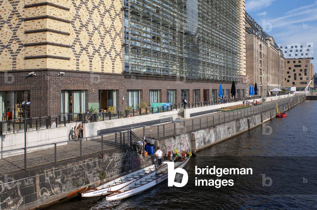 Rowing boat on the Spree near Panoramic view of Berlin skyline with famous Molecule Man sculpture and Spree river in beautiful post Berlin, Germany (photo)