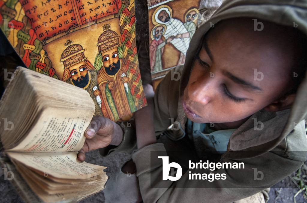 Lalibela, Amhara region, Ethiopia, A child prays in one of the Lalibela churches (photo)
