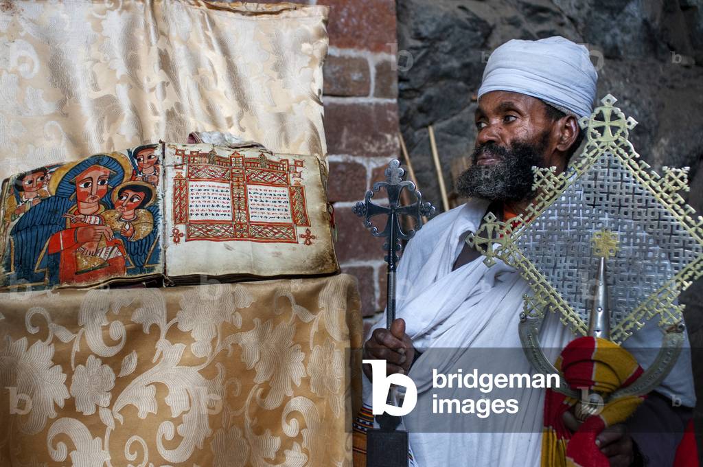 Portrait of an ethiopian orthodox priest holding a cross in nakuto lab cave church, Amhara region, Lalibela, Ethiopia (photo)