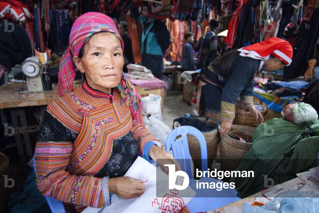 Black hmong women making and selling tribal handicrafts and clothes iniside the market in Sapa, Lao Cai Province, Vietnam (photo)