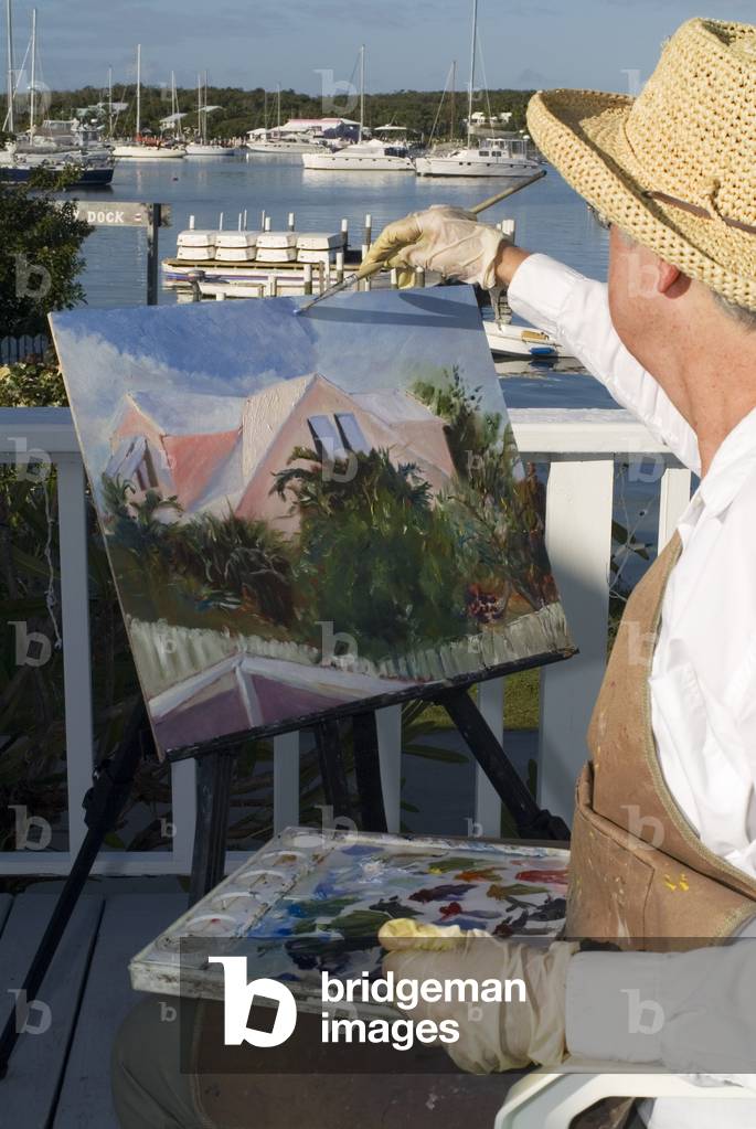 Woman painter painting the Hope Town Harbour, Bahamas (photo)