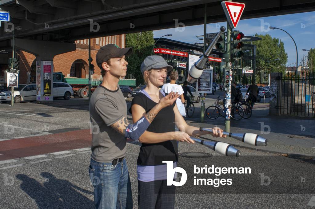Young couple jugglery performing on pedestrian crossing near  Oberbaum bridge Oberbaumbrucke in  Friedrichshain Kreuzberg Berlin, Germany, Europe (photo)