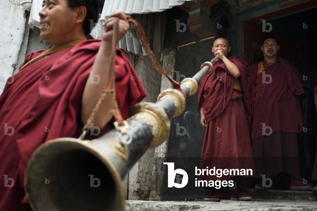 Monks playing the Tibetan horn inside Tashilumpo Monastery at Shigatse, Tibet, China (photo)