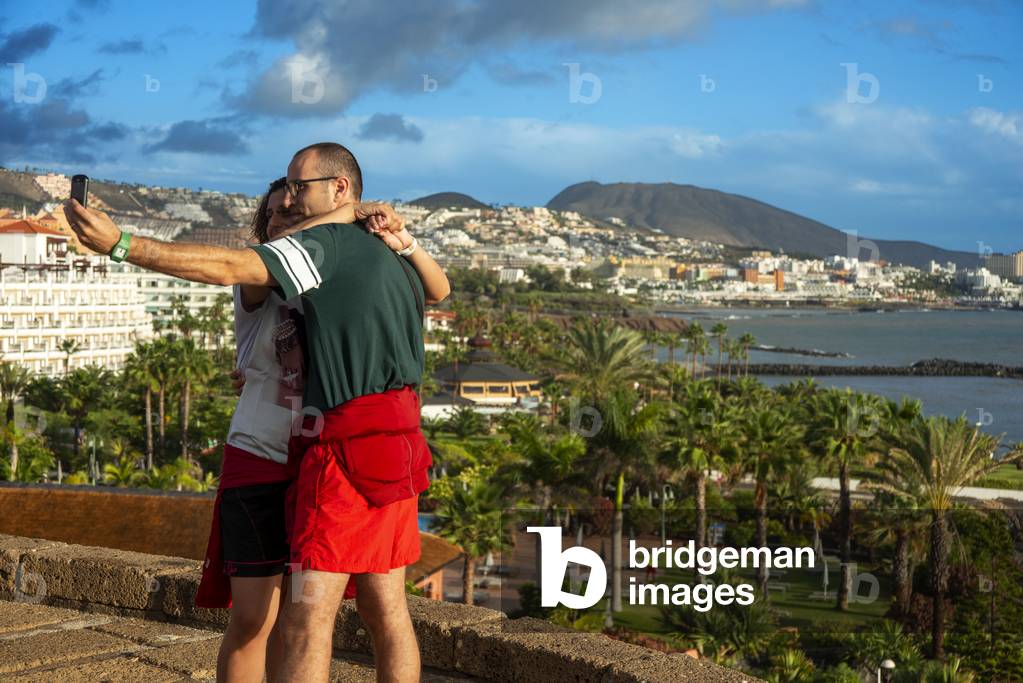 Couple of turists in La Caleta in Costa Adeje coastal front Tenerife Island, Canary Islands, Spain (photo)