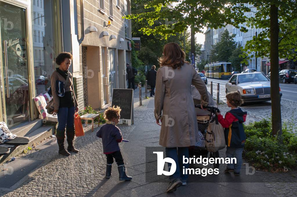 Family with children walking around Invalidenstrasse street near Berlin Kollwitzplatz in Prenzlauer Berg in, Berlin, Germany (photo)