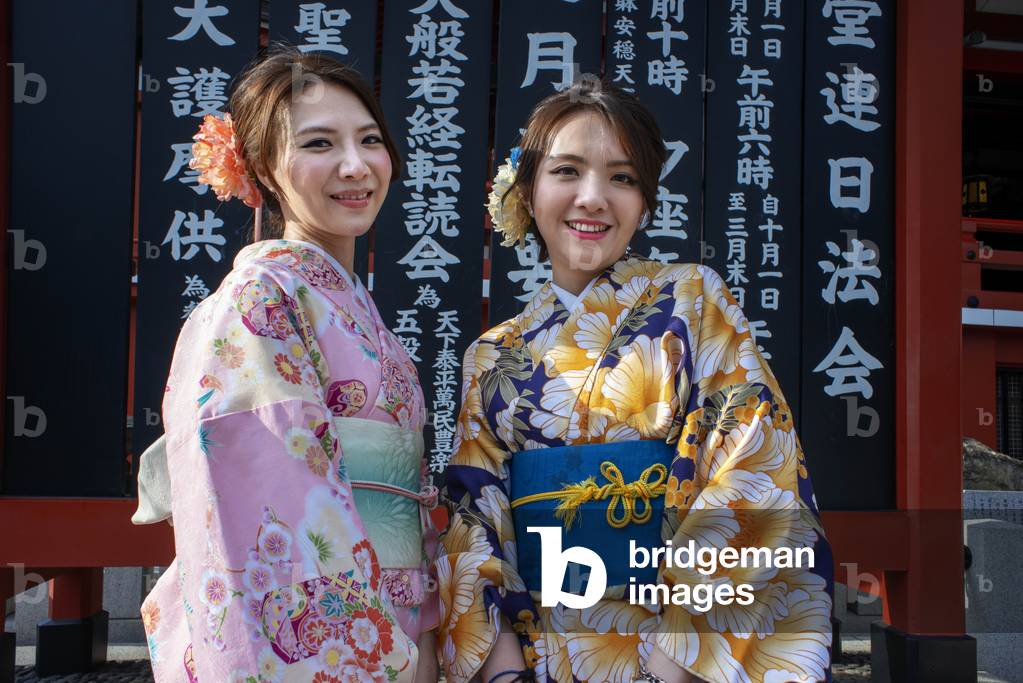 Women wearing kimono, the national tradition costume of Japan, walking on Nakamise dori, a street with food and souvenirs shops, Senso-ji Buddhist Temple in Asakusa, Tokyo, Japan, March 2020 (photo)