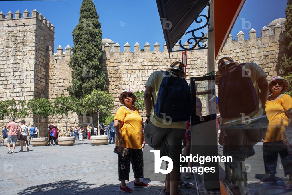 Asian tourists in the walls of Real Alcazar Seville, Spain (photo)