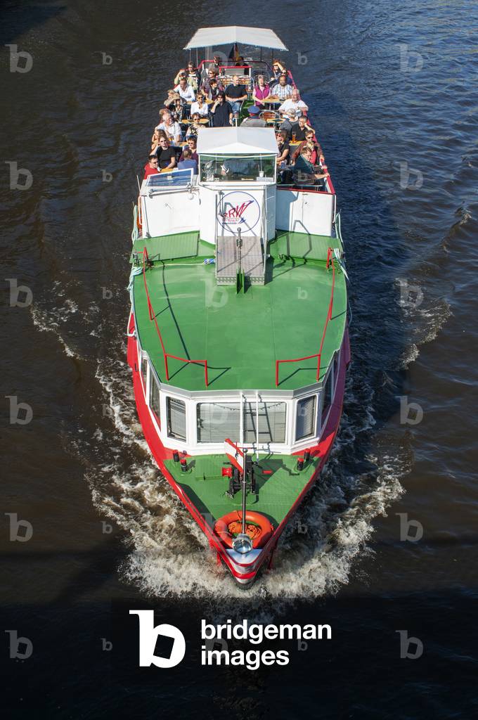 Touristic boat along the The River Spree, running alongside the Nikolaiviertel, leads towards the historical landmark of Berlin Cathedral, Germany (photo)