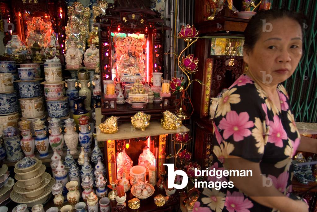 Buddhist worshippers praying in the family temple in his shop Hanoi, Vietnam (photo)