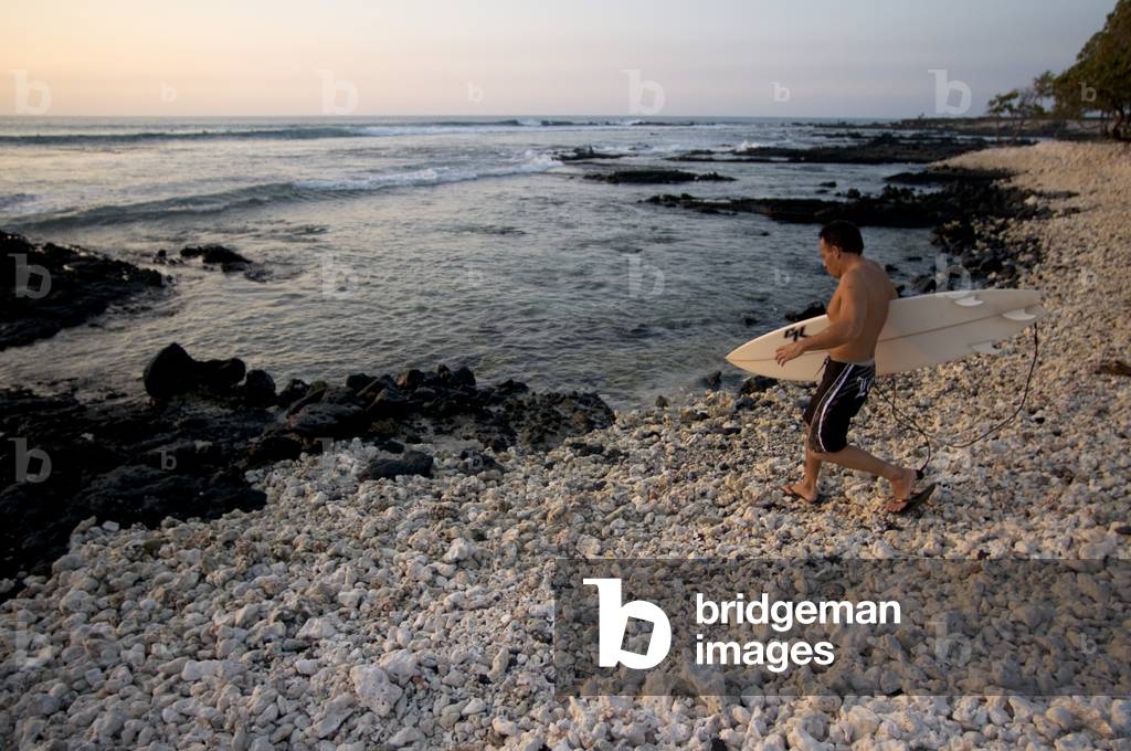 Surfer on the beach in Waikoloa, Big Island, Hawaii (photo)