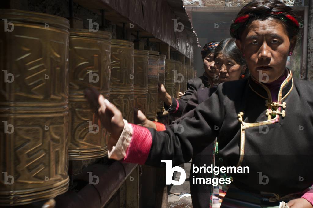 Several women spin the prayer wheels at Tsepak Lhakhang Monastery, Lhasa, Tibet (photo)