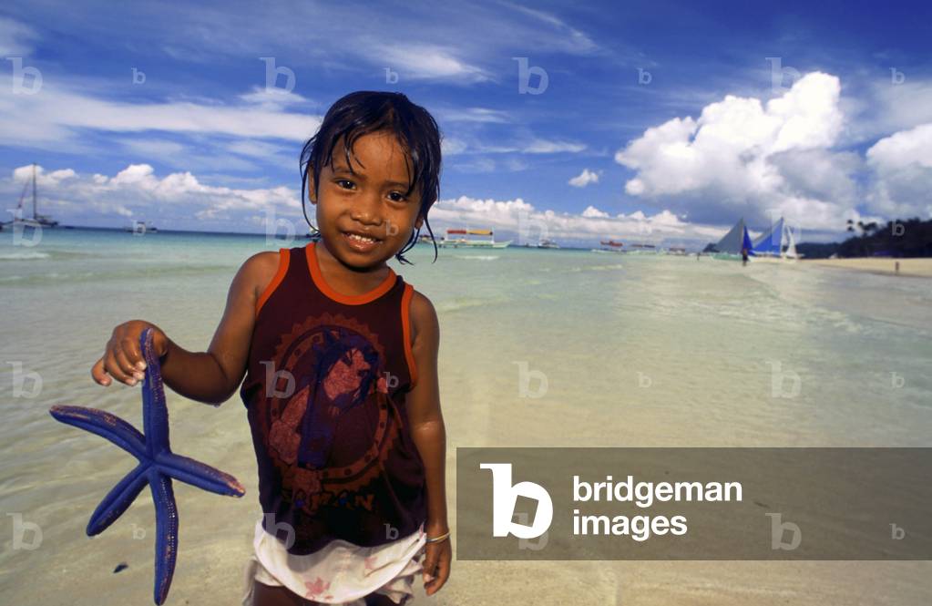 Girl holding a starfish, Boracay, Philippines (photo)