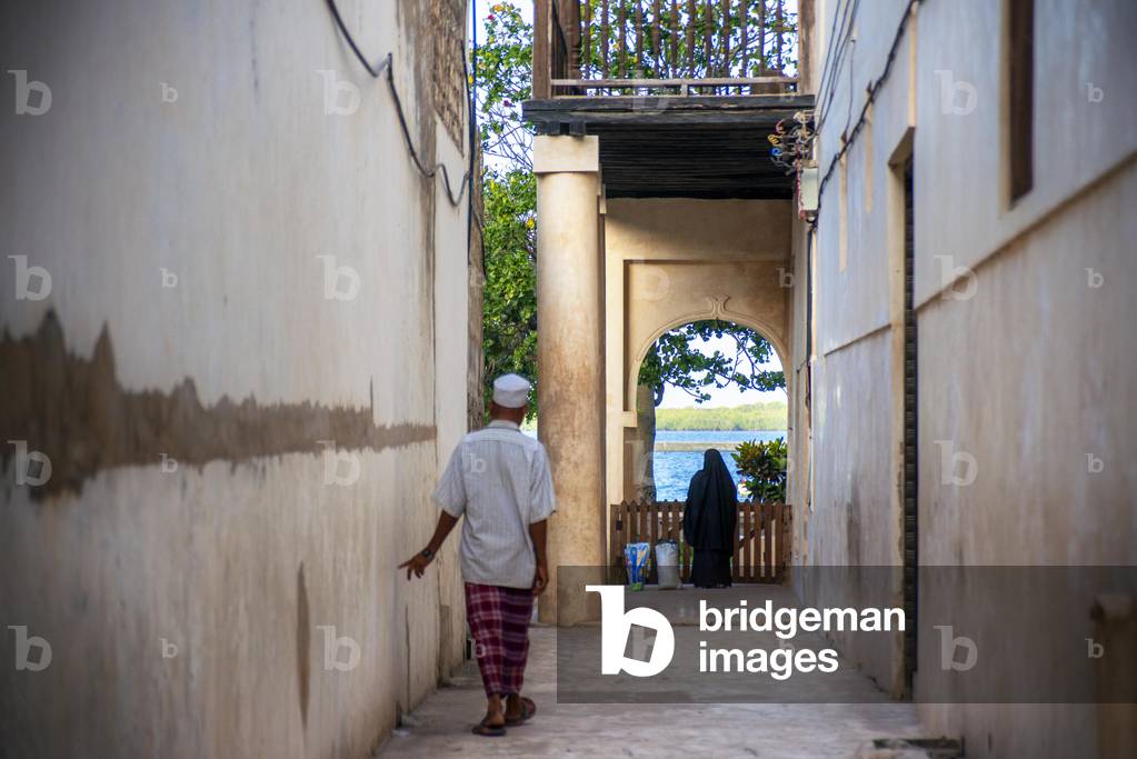 Local people in a narrow street of Lamu town in Lamu Island, Kenya, 2020 (photo)