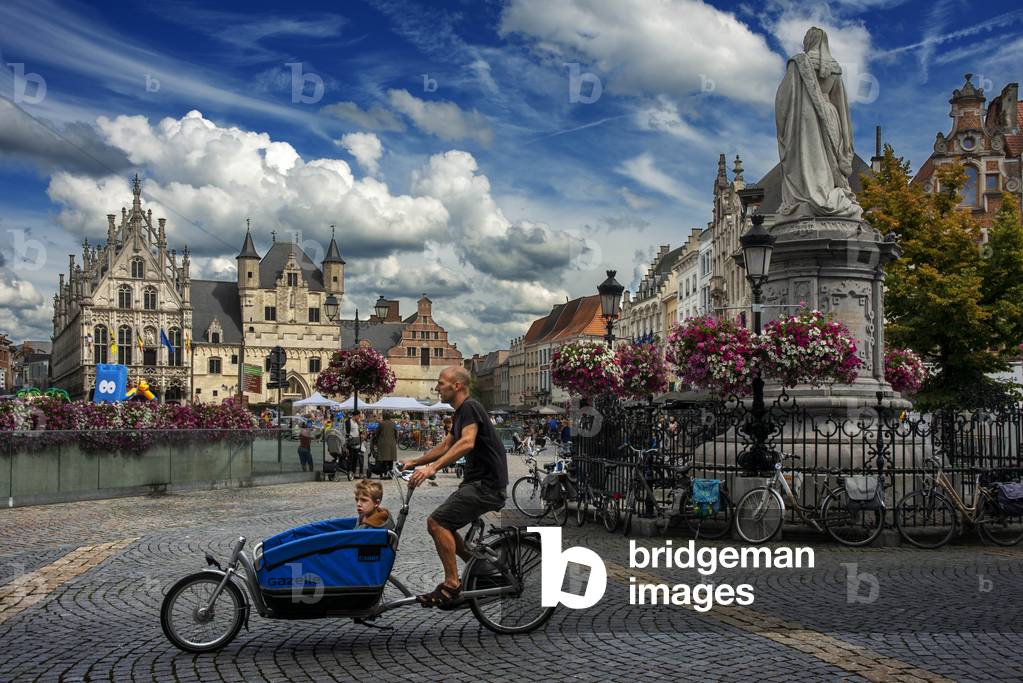 Family fashion bicycle passing in front of Grote Markt (Main Square), Mechelen, Belgium (photo)