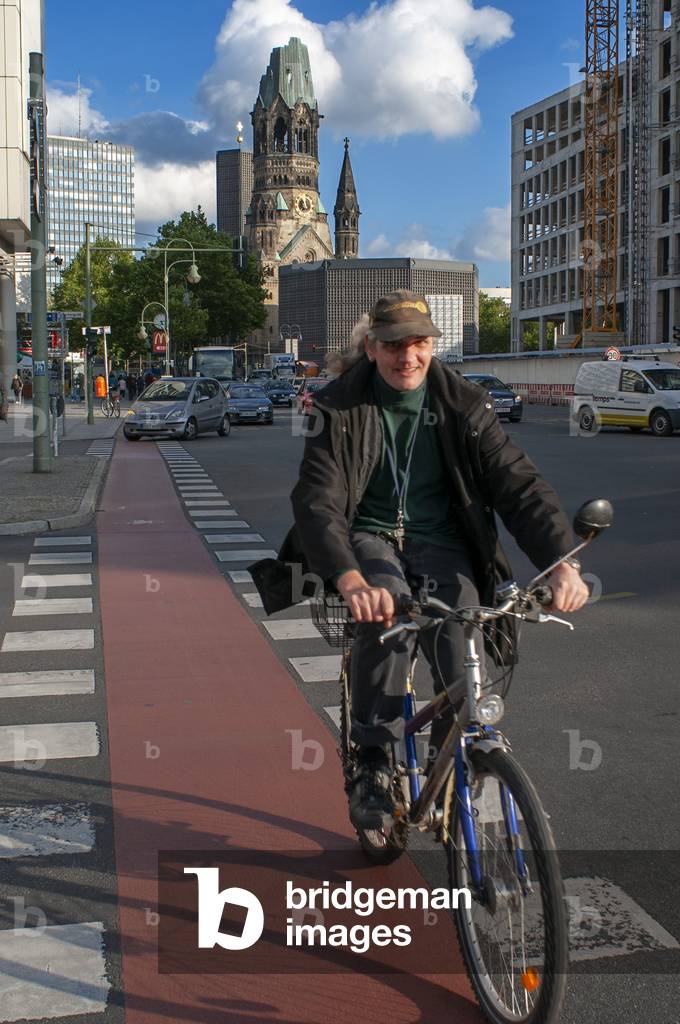 Man on a bicycle near Kaiser Wilhelm Memorial church at Kurfuerstendamm, Berlin, Germany, Europe (photo)